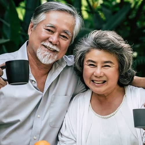 An older couple drinking tea in a garden, potentially illustrating a tranquil retirement or leisure setting.