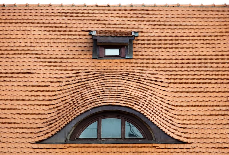 Eyebrow window on a house is a low dormer on the slope of a roof. It has no sides, and the roofing is carried over it in a wavy line.