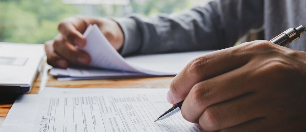 Man filling out tax paperwork, income is assessed for mortgages.