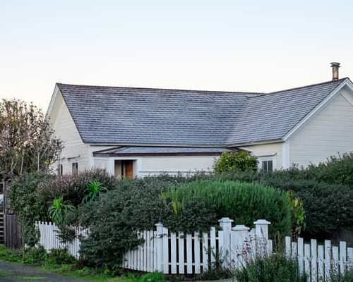 A charming row of houses with a white picket fence, creating a picturesque neighborhood scene.