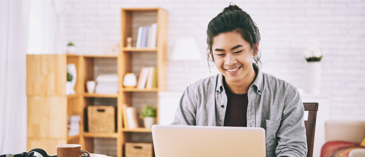 A college student using a laptop, representing education loans.