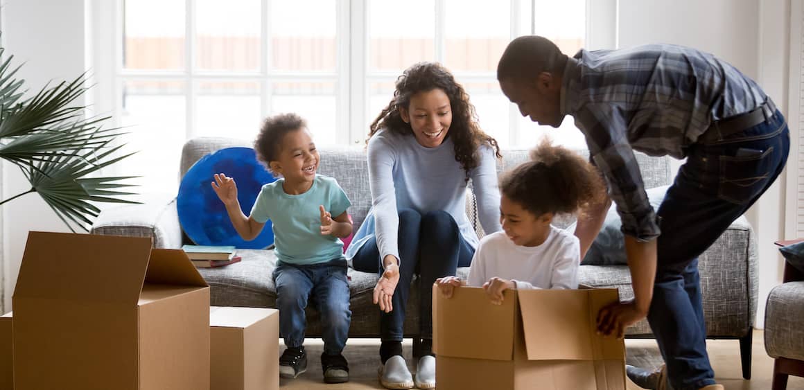 Family moving into a home, unloading boxes and settling into their new living space.