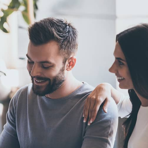 Loan officer reviewing mortgage paperwork with smiling couple.