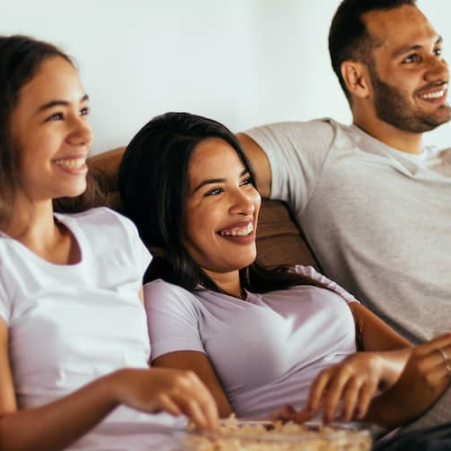 Young Latino family happily settled in their forever home, expressing contentment and stability.