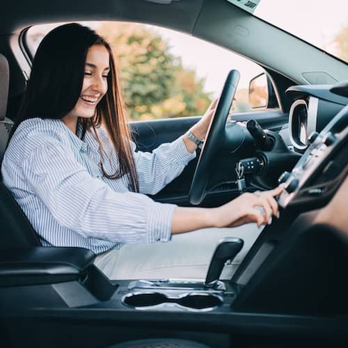 Young woman in the driver’s seat of a car.