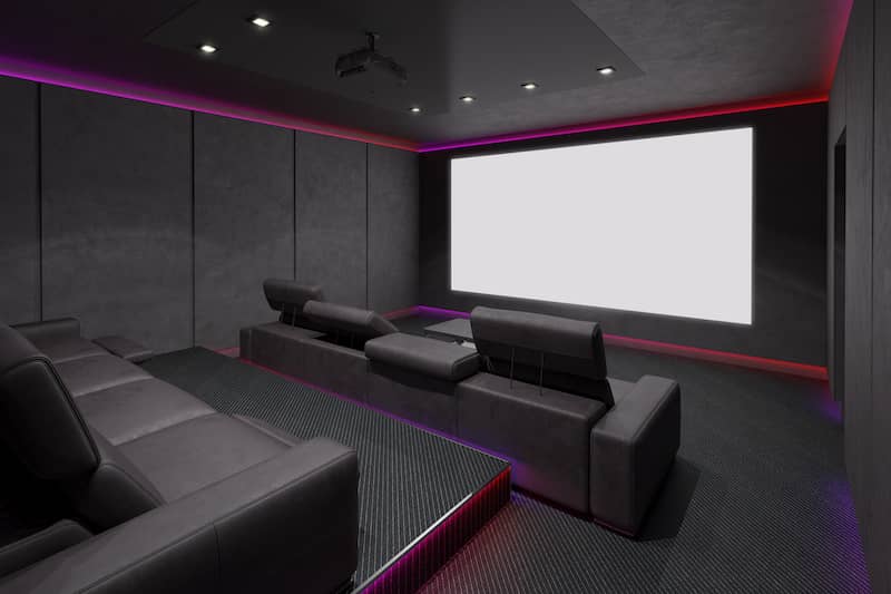 RHB Assets From IGX: Futuristic home theater with a large screen, curved seating, and ambient lighting.