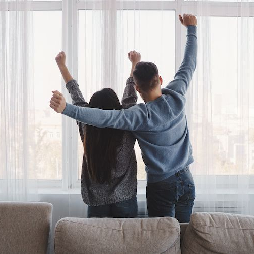 Just married couple first house, possibly depicting a newlywed couple celebrating their first home looking outside the window.