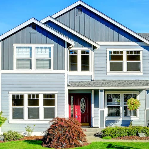 Large two-story house with a garage and car parked on driveway.