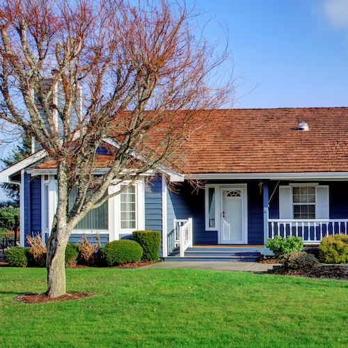 A blue ranch-style house with white trim, showcasing a residential property.