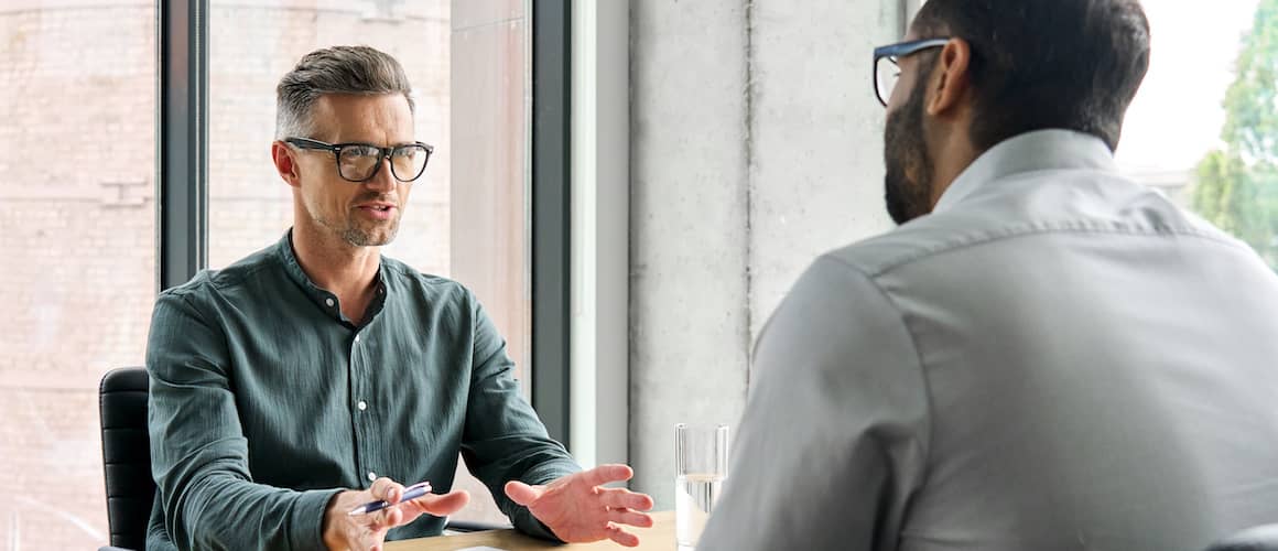 Two businessmen discussing finances in a bright office.