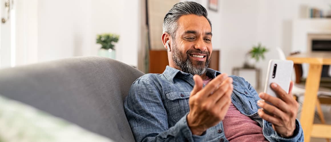 A man checking his phone, possibly related to real estate or mortgage updates.