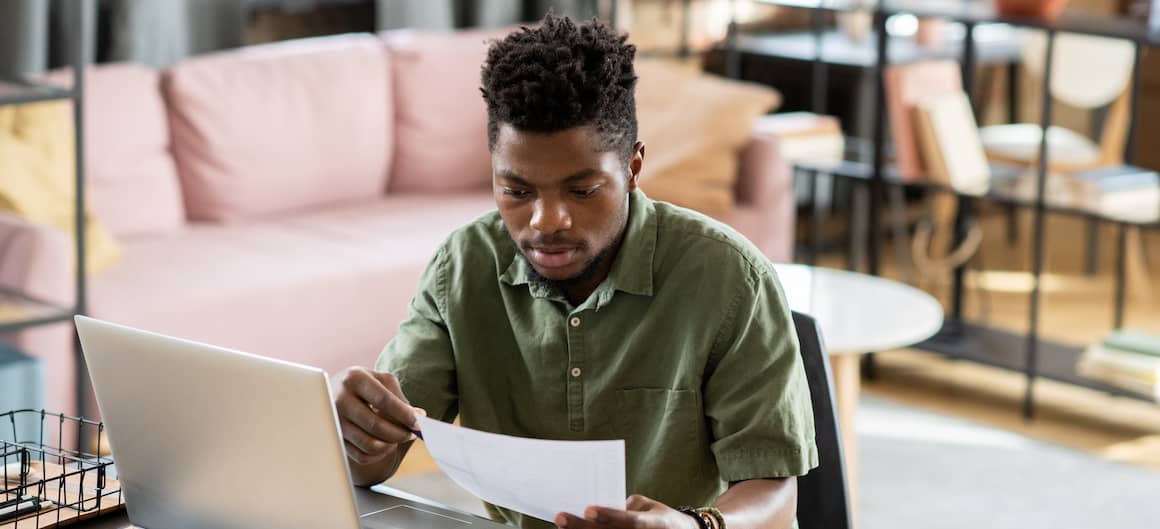 A focused image of a man engrossed in working with paperwork, indicating involvement in real estate transactions, financial planning, or administrative tasks related to home buying or mortgage processes.