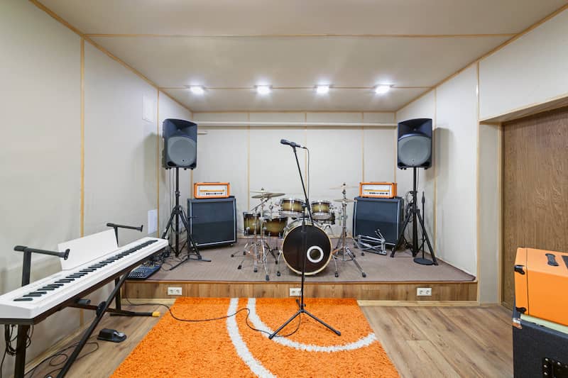 RHB Assets From IGX: Garage converted into a band practice space with musical instruments and equipment.