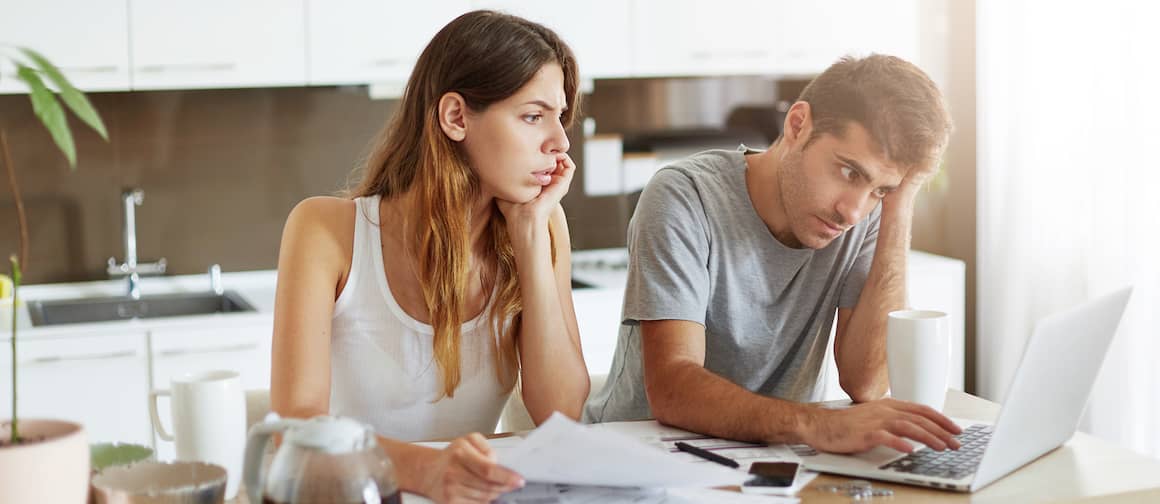 Couple looking over their debt on computer.