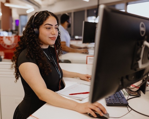 Woman wearing headset in office on monitor.
