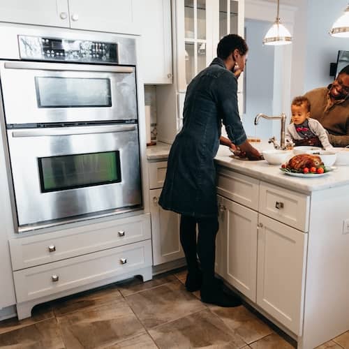 Family cooking dinner together in newly remodeled kitchen.