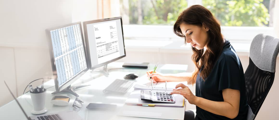 Woman doing taxes at desk.