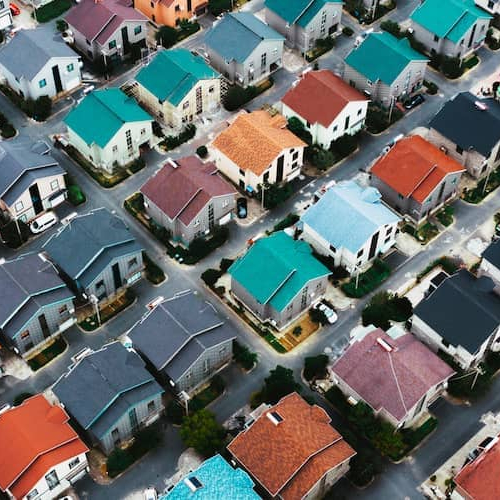 Aerial view of vibrant and colorful neighborhood, showcasing diverse houses and surroundings.