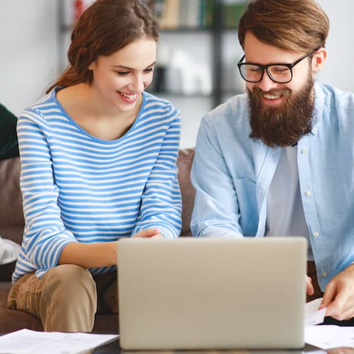 A couple paying their mortgage online using a laptop.