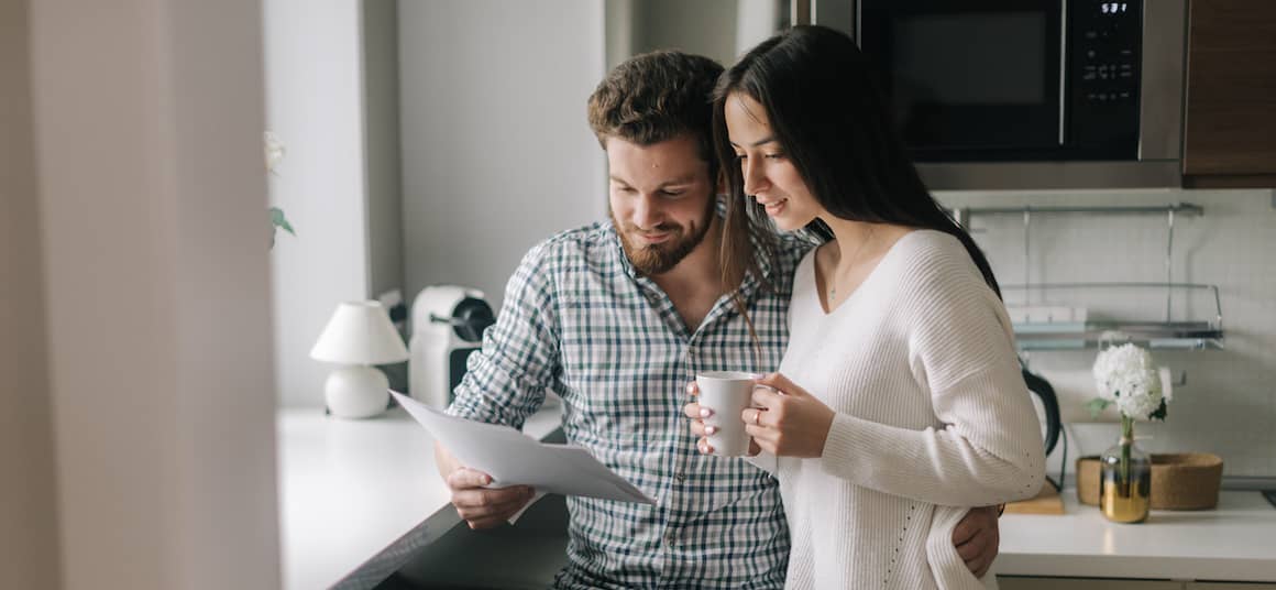 A couple looking at documents, possibly related to real estate or financial decisions.