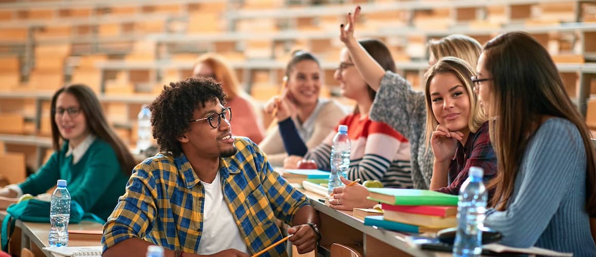 Group of students in an indoor college amphitheater studying together.