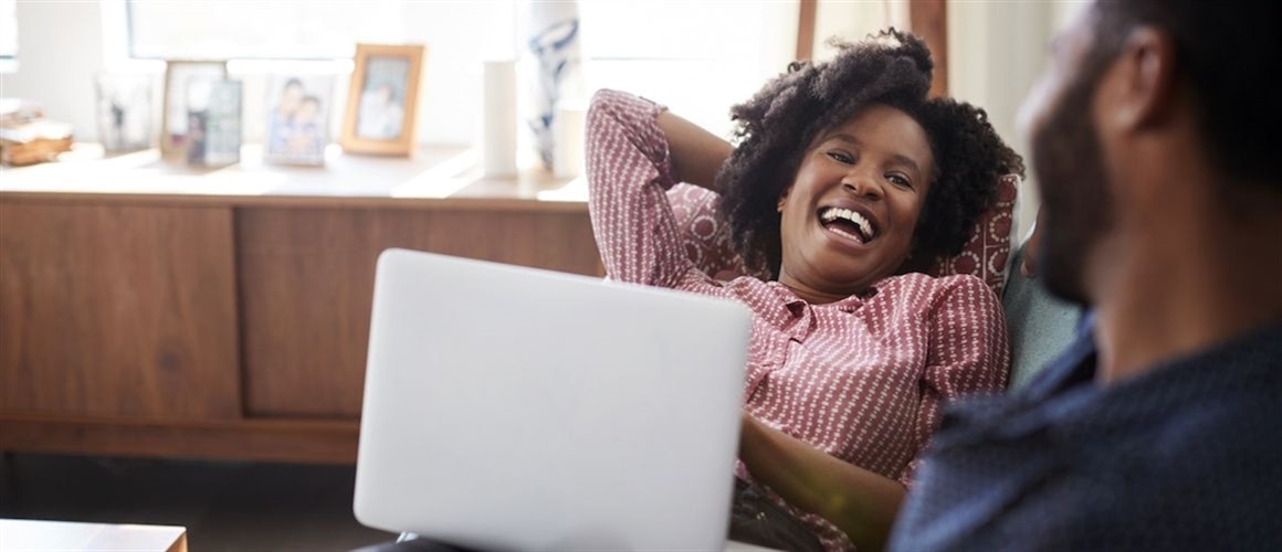 Woman smiling on computer because she improved her credit score.