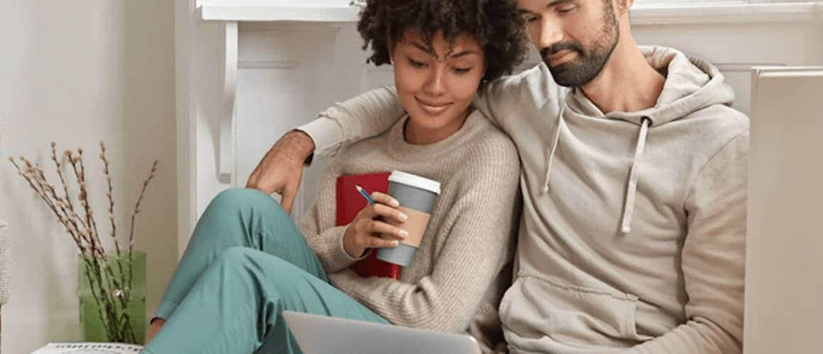 A couple discussing financial or mortgage related topic on laptop.