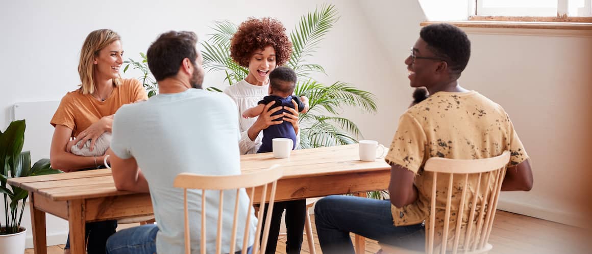 A diverse group of individuals gathered around a table, engrossed in conversation.