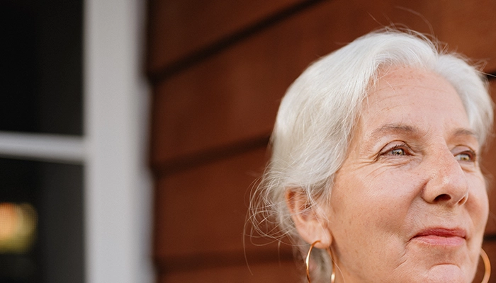 Woman looking off into distance smiling softly.