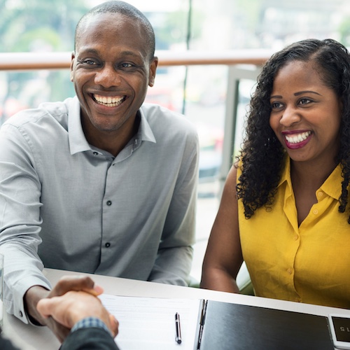 African American couple meeting with a banker in an office.