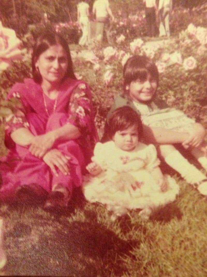 Mother and daughters sitting among roses.