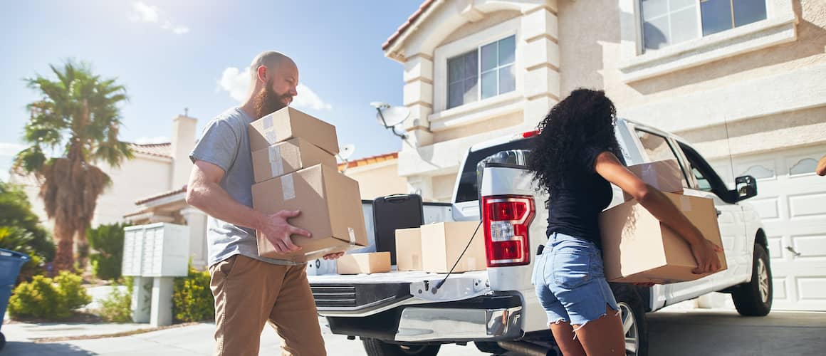 RHB Assets From IGX: A man and woman moving into a new house from a truck