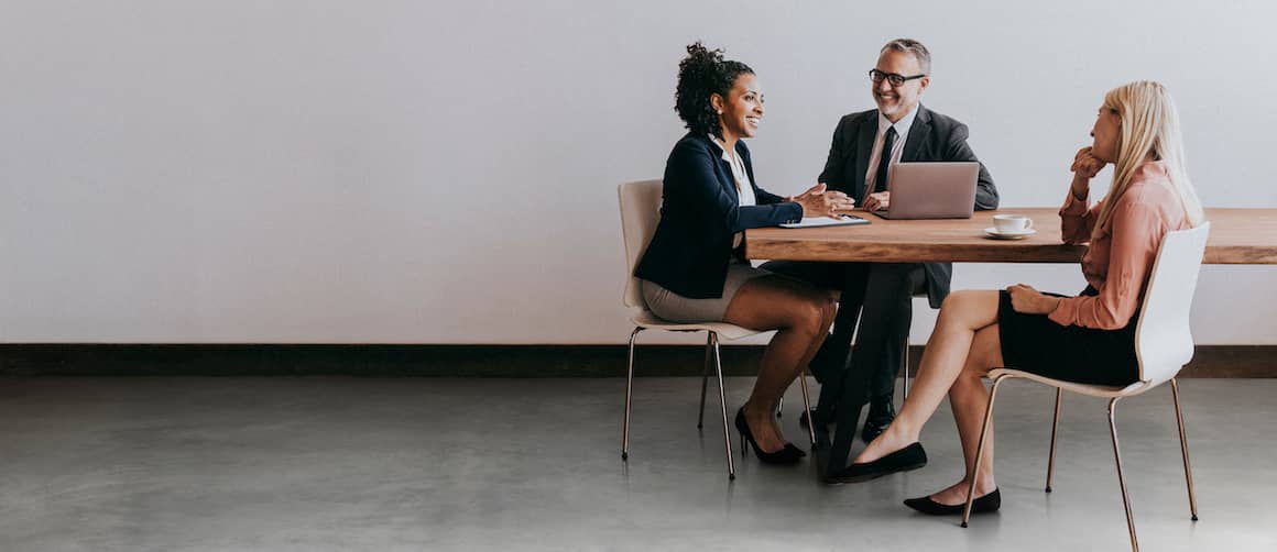 Three businesspeople sitting around table.