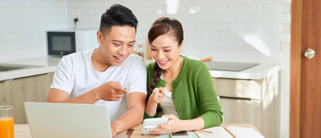 Stock-Young-Couple-Looking-At-Papers-In-Kitchen-AdobeStock-404756711-Copy.jpg