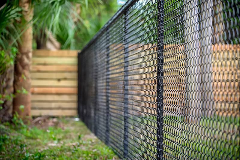 RHB Assets From IGX: Chain-link fence surrounding a lush green park with trees.