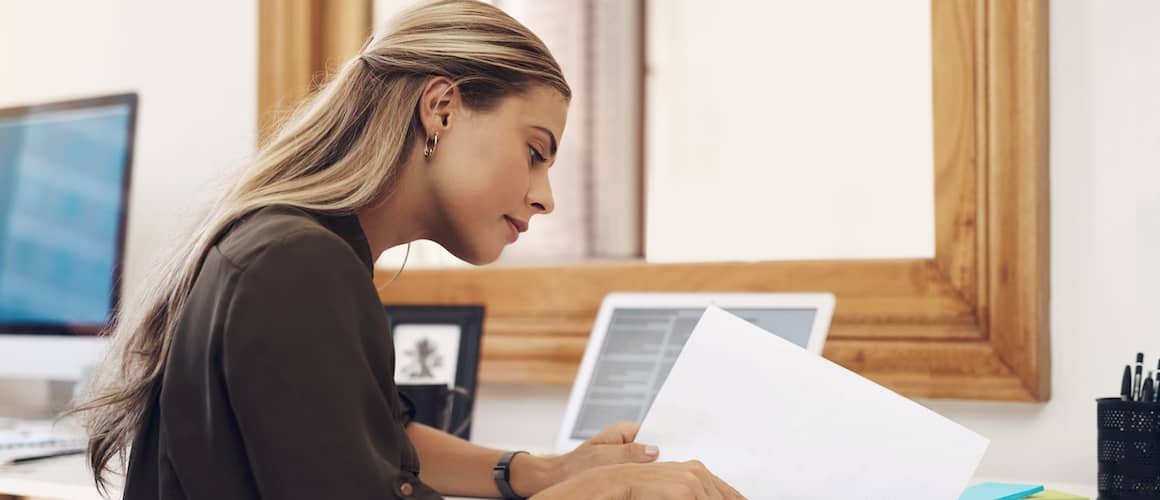 Woman calculating finances at home office desk.