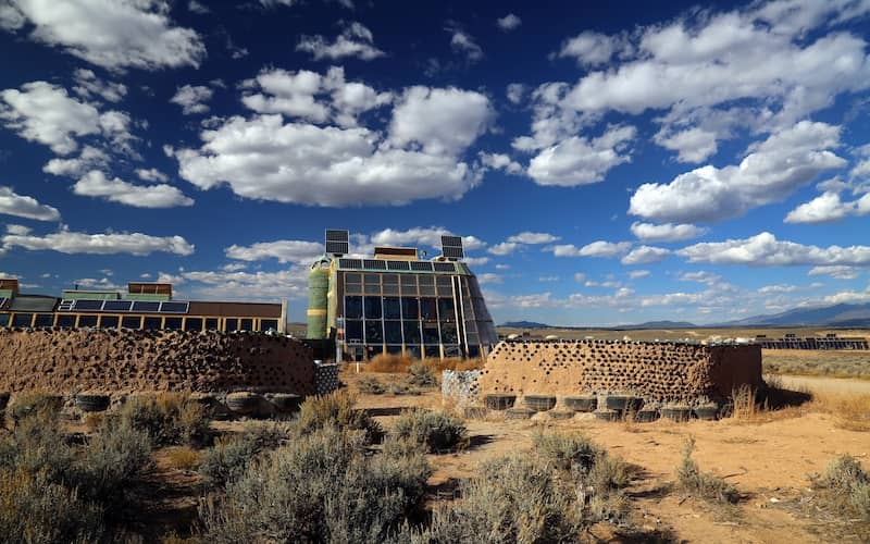 Front entrance view of an Earthship home and blue skies.