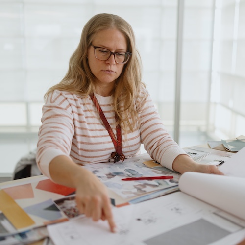 Team member sorting through documents and pointing to a paper.