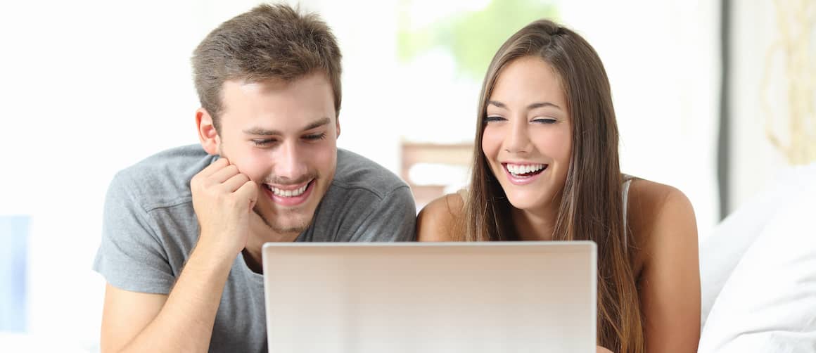 Young couple receiving good news on the computer.