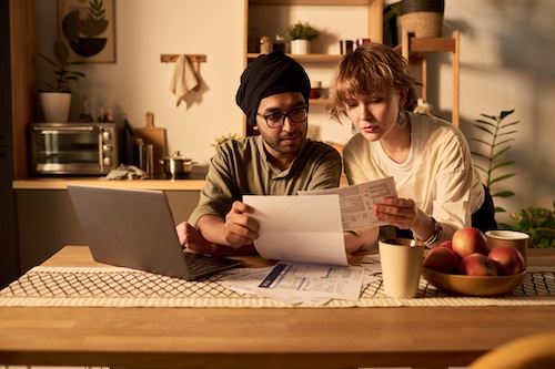 Couple reviewing finanial documents in their kitchen.