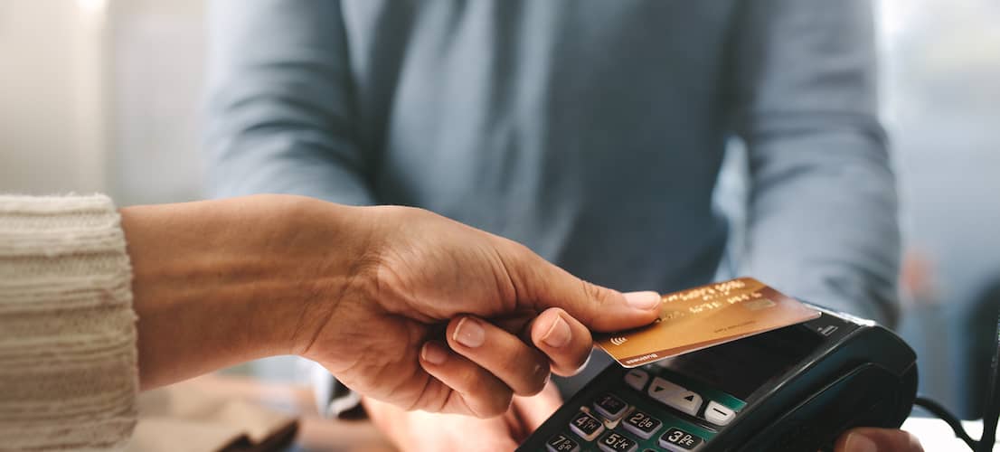 Close up of woman paying with credit card at a retailer.