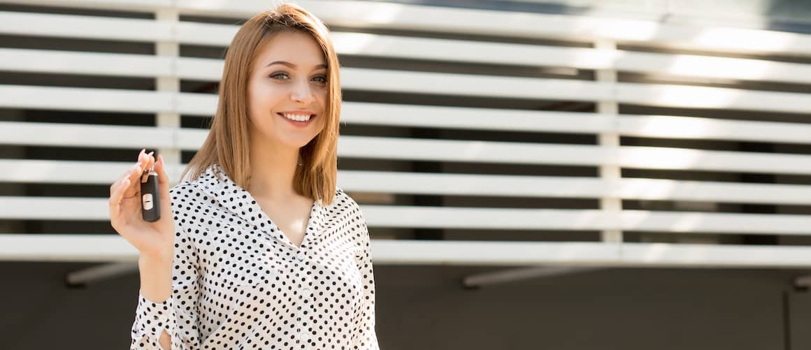 Woman holding up a set of new car keys.