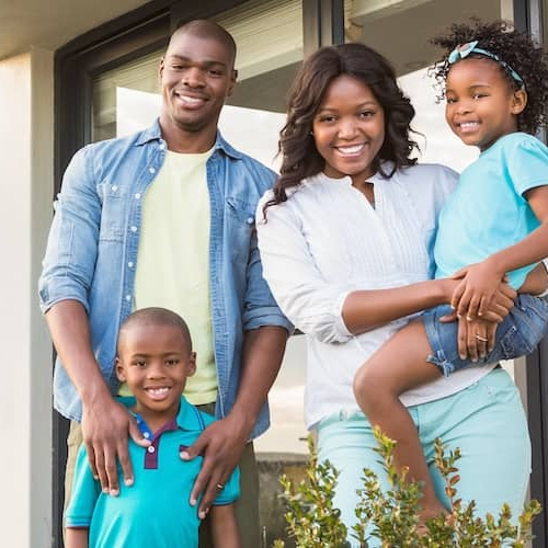 An African American family outside a modern home, portraying a sense of homeownership and family life.
