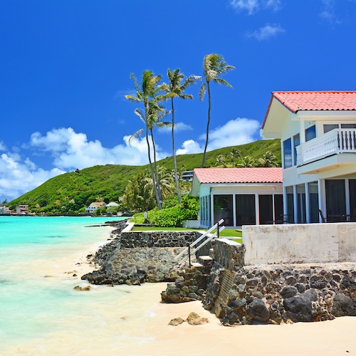 House on beach with palm trees in Hawaii.
