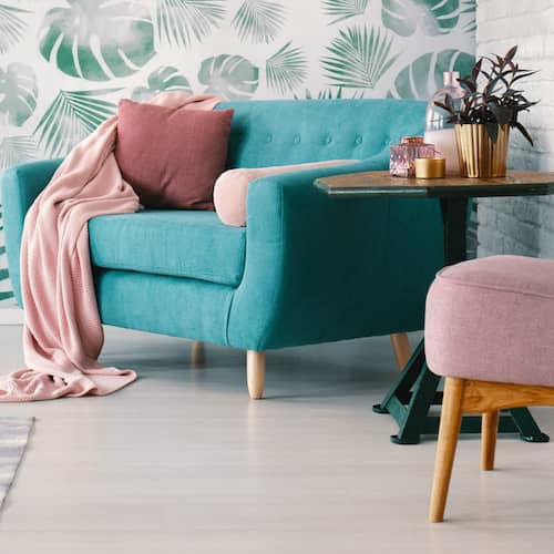 RHB Assets From IGX: Bright and modern living room featuring a turquoise sofa, green accents, and large windows.