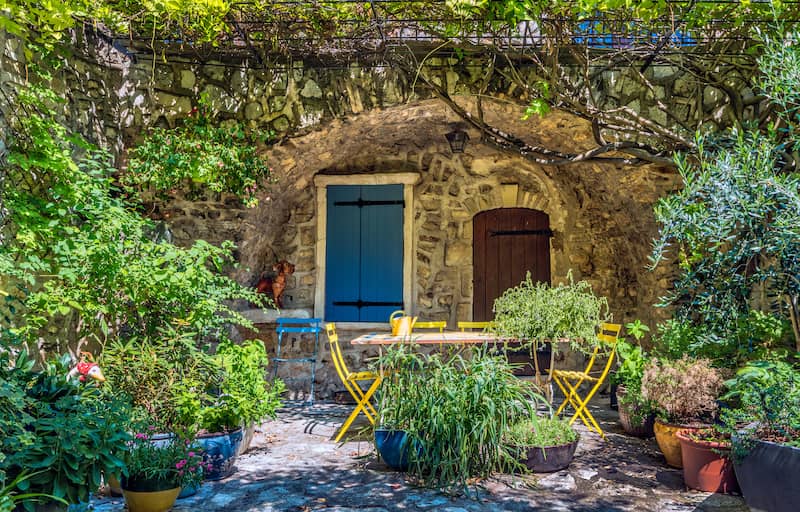 Exterior view of earth berm home’s front door among colorful garden.