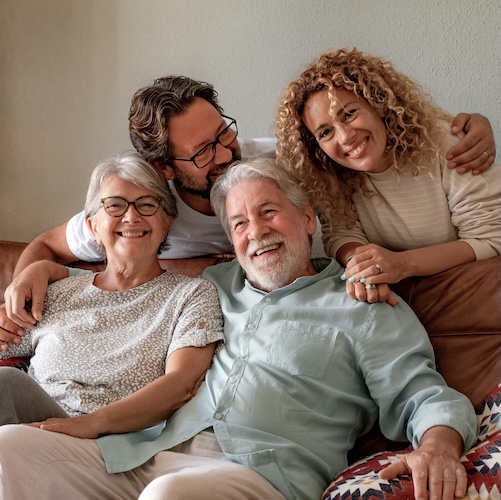 Middle aged couple and elderly couple laughing together.