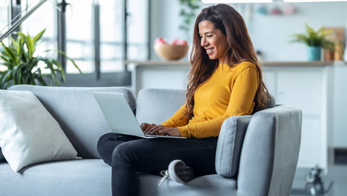 RHB Assets From IGX: A woman working on a laptop on a sofa