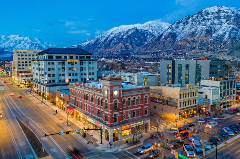 View of downtown Provo, Utah with snow-capped mountains in the background.