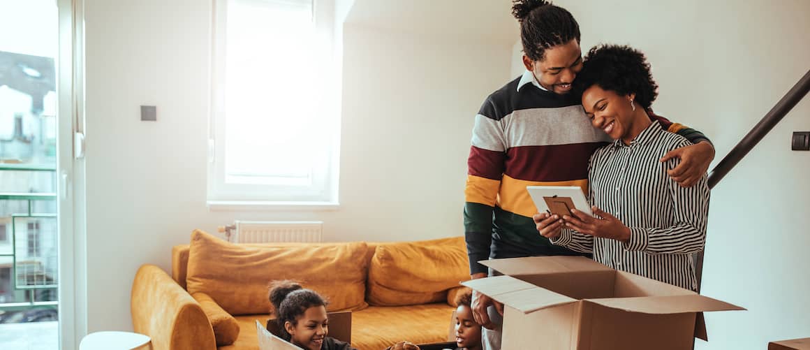 A happy African-American family unpacking, portraying diversity in the context of homeownership and moving into a new house.
